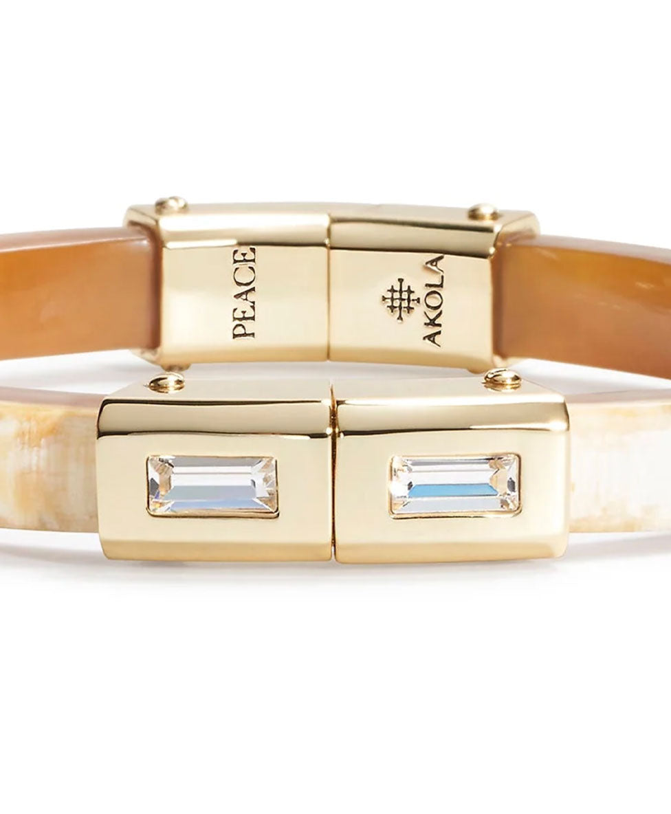 Gold bracelet with gemstone accents on a white background