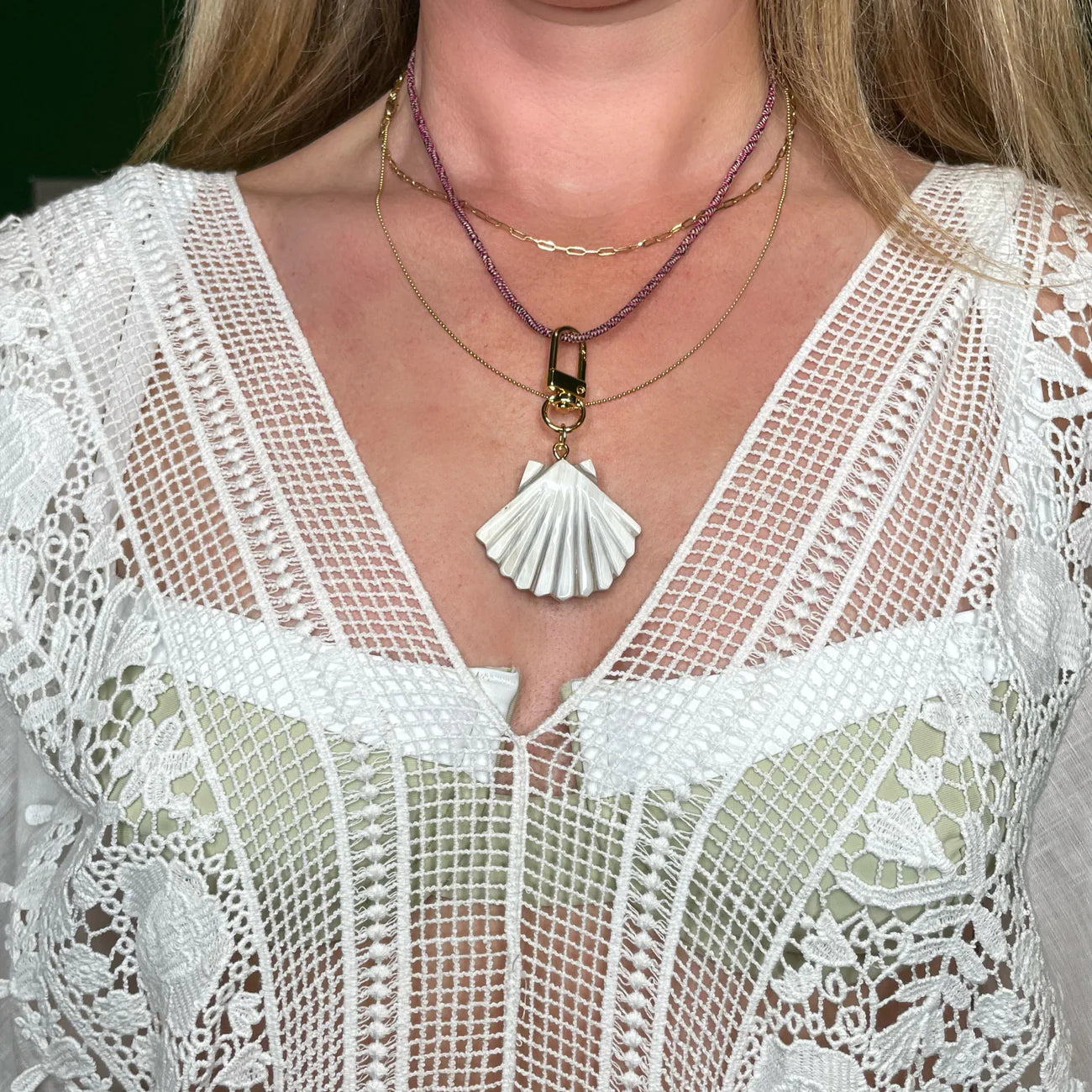 Detail of Akola horn sea shell charm on raffia braid
