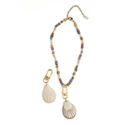 Side view of Akola scallop shell charm in hand-carved horn