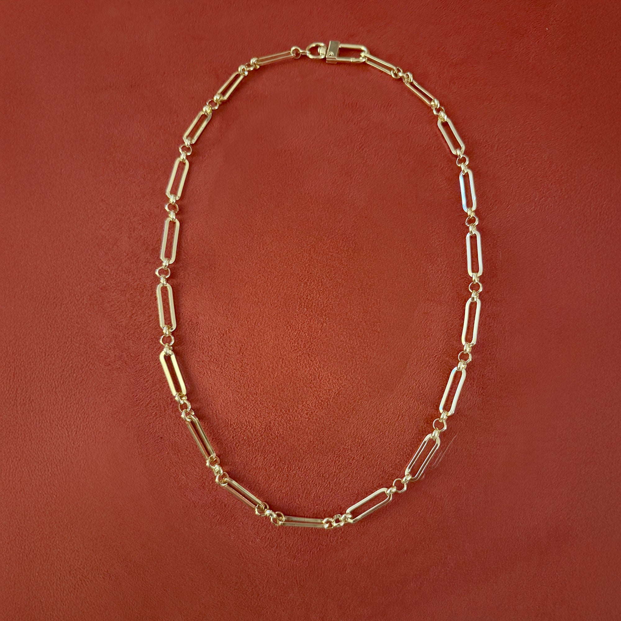 Gold chain necklace on a brown background