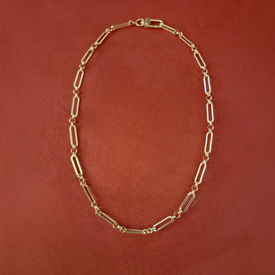 Gold chain necklace on a brown background