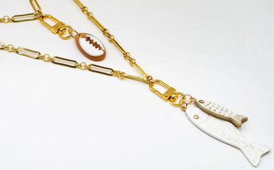 Lilly Sisto x Akola double fish charm layered with a short puka shell strand